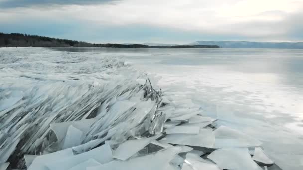 Χειμερινό τοπίο στην όχθη του ποταμού. Αιχμηρός πάγος στην ακτή, προεξέχει από το νερό. Χειμώνας και κρύο πάγωσε τη δεξαμενή. — Αρχείο Βίντεο
