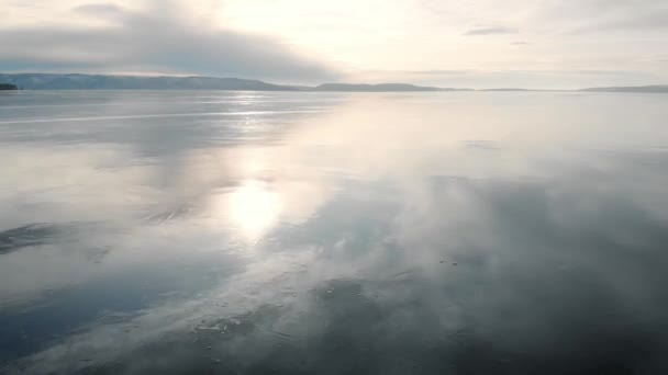 Its an aerial view. The winter landscape of the freezing river. The ice reflects the sky and the sun. Cold temperature. — Stock Video