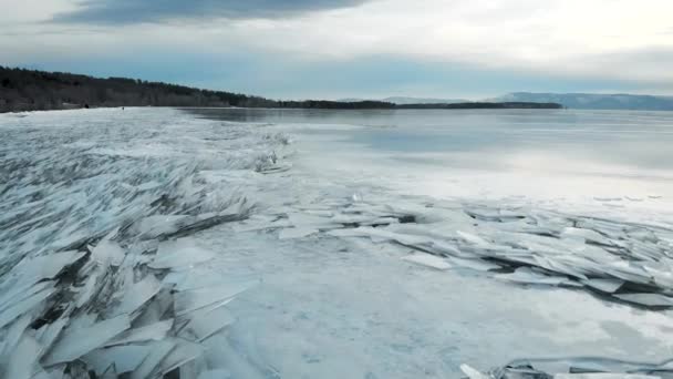 Paysage hivernal sur la rive. Glace vive sur le rivage, sortant de l'eau. L'hiver et le froid ont gelé le réservoir . — Video