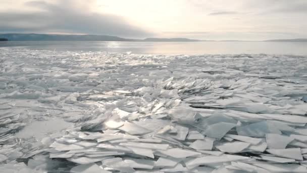 Το βόρειο τοπίο μιας παγωμένης λίμνης ή ποταμού. Θραύσματα πάγου κοντά στην ακτή, σε απόσταση βουνά και ορίζοντα. — Αρχείο Βίντεο