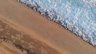 Yukarıdan üst hava manzarası. Donmuş nehrin kıyılarının güzel bir tasarım manzarası. Kumlu sahil buzun kenarında duruyor. Sonra buz kütleleri soğuk suda yüzüyor..