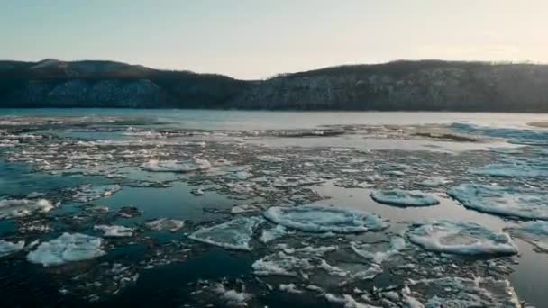 航拍。 冰冻的河流的映像，在被雪覆盖的光秃秃的高山上。 一个寒冷的冬季风景。 季节 — 图库视频影像