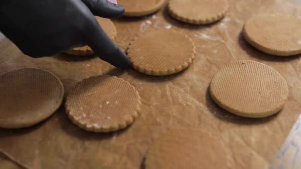 Lebkuchen gebacken. der Konditor legt die fertigen Plätzchen aus, verwendet Pergament. — Stockvideo