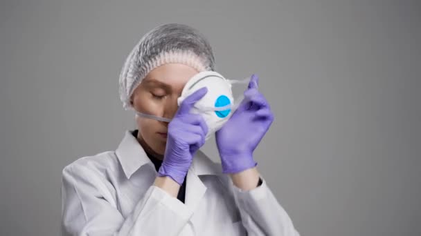 Una dottoressa si prepara ad andare in pazienti infetti. Sul viso della maschera e del cappuccio protettivi, il dispositivo di protezione fionda protegge contro il coronavirus. 2019-ncov — Video Stock