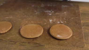 Fırında zencefilli ekmek. Pasta şefi bitmiş kurabiyeleri hazırlar, parşömen kullanır..