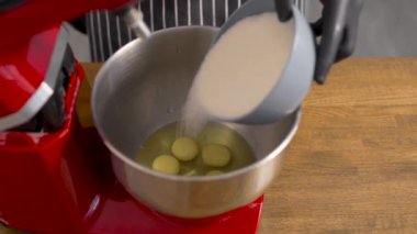 Pour the sugar sand into a special kitchen mixer. The process of mixing ingredients for the dough.