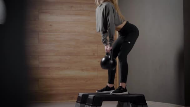 The girl in the sports room performs exercises. Squats with and without weight are well suited to maintaining a figure. A beautiful, fit body. — Stock Video