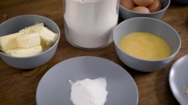 Şef bir pasta şefi, malzemeleri ve aksesuarları masaya diziyor. Zencefilli çörek hazır olacak. Baharatlı