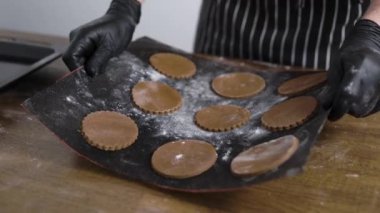 Erkek aşçı demir bir tavaya zencefilli kurabiye koydu. Bir pasta şefi kurabiye pişirmeye hazır..