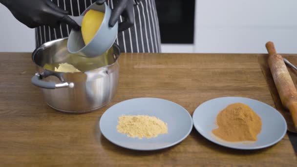 Närbild del av köksbordet med stekpannor och tallrikar. Konditor sydde ingredienserna för att göra degen till muffins eller pepparkakor. — Stockvideo