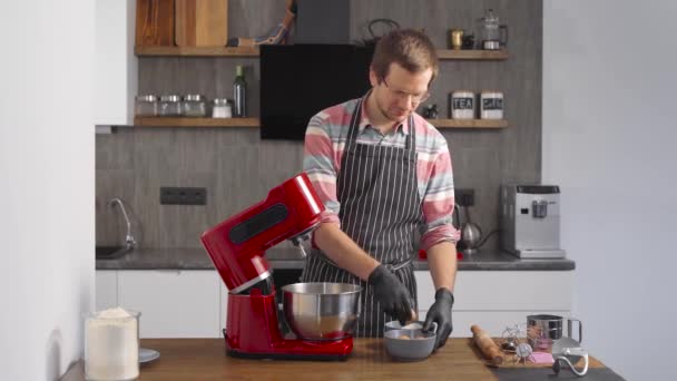 O cozinheiro usa um misturador de cozinha. Um homem mistura os ingredientes para a preparação da massa . — Vídeo de Stock