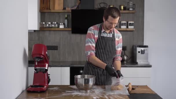 El cocinero ha preparado una masa para magdalenas o pan de jengibre. El cocinero quita la masa para lo que sea . — Vídeo de stock