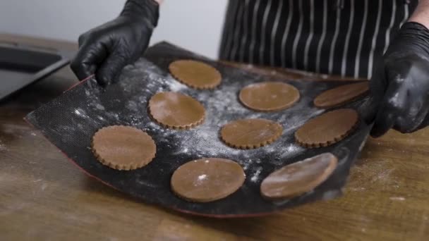 Αρσενικό μάγειρα έβαλε μπισκότα μελόψωμο σε ένα τηγάνι σιδήρου. Ένας ζαχαροπλάστης είναι έτοιμος να ψήσει μπισκότα.. — Αρχείο Βίντεο