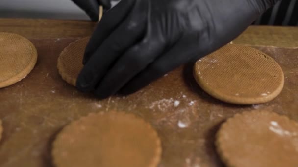 焼きジンジャーブレッド。ペストリーシェフは、完成したクッキーをレイアウトし、羊皮紙を使用しています. — ストック動画