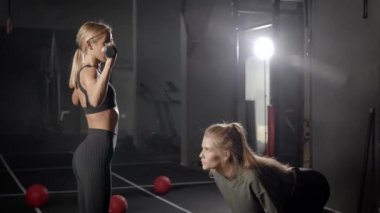 Spor salonunda iki güzel sarışın. Kızlar egzersizleri hafif sıkletle yaparlar. Sağlık ve rakamların izlenmesi önemlidir..