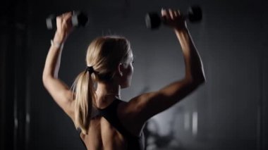 Beautiful young blonde is engaged in fitness. The woman performs exercises to maintain the figure. Slender body of a young girl. Healthy