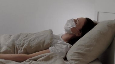 Hastane yatağında koronavirüsü olan bir hasta. Kız öksürüyor, ateşi var ve titriyor. Hastalığın akut bir formu..