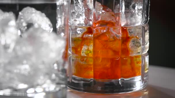 Mixen eines Cocktails aus verschiedenen Flüssigkeiten in einem Eisglas. — Stockvideo