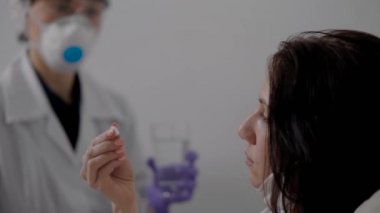 doctor is giving medicament for patient in hospital room, sick woman is taking pill and drinking water
