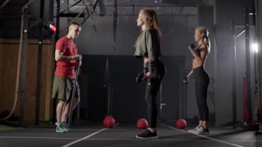 two athlete women are training with dumbbells in fitness club, personal workout with coach