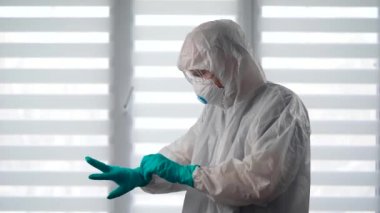 Salgın Covid-19. Koruyucu kıyafetli bir virüs uzmanı portresi. Bir erkek epidemiyoloji uzmanı enfeksiyonla savaşmaya hazır..