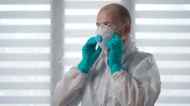 Salgın Covid-19. Koruyucu kıyafetli bir doktorun portresi. Anti-viral hijyenik önlemler