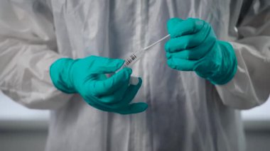 Salgın Covid-19. Doktorların yakın çekimleri koruyucu eldivenler veriyor. Bulaşıcı madde, hasta bir insanın analizini içeren bir matara tutuyor..