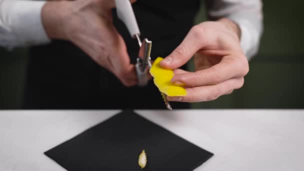 Il barista taglia la scorza di limone per decorare il cocktail . — Video Stock