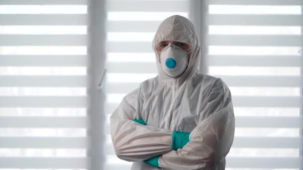 Pandemic Covid-19.保護服の中のウイルス学者の肖像画。男性疫学者は感染症と戦う準備ができています. — ストック動画