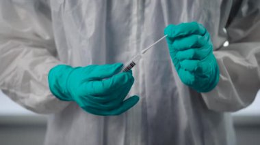Salgın Covid-19. Doktorların yakın çekimleri koruyucu eldivenler veriyor. Bulaşıcı madde, hasta bir insanın analizini içeren bir matara tutuyor..