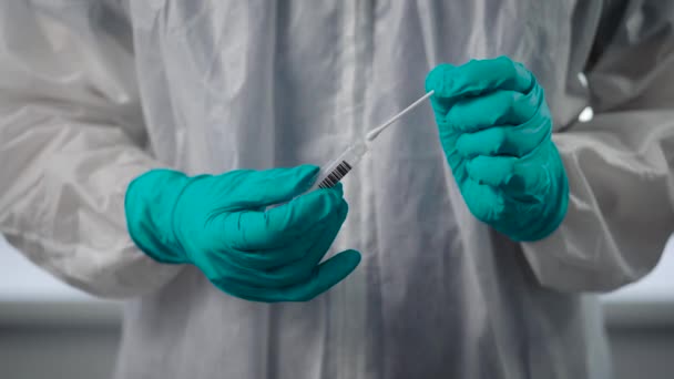 Pandemic Covid-19.医師の近くに保護手袋を手に。感染剤は病気の人の分析とフラスコを保持しています. — ストック動画