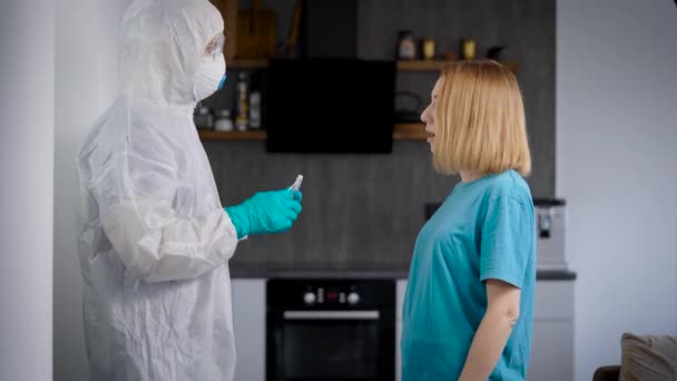 Covid-19 pandémico. El médico toma la prueba en una persona infectada con el virus. Una mujer en casa, haciendo una prueba para un patógeno peligroso . — Vídeo de stock