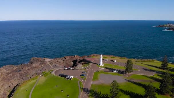 Kiama, una ciudad turística en Australia. Una vista aérea del pintoresco promontorio rocoso. Un faro blanco se encuentra en el océano . — Vídeo de stock