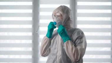 Salgın Covid-19. Koruyucu kıyafetli bir virüs uzmanı portresi. Bir erkek epidemiyoloji uzmanı enfeksiyonla savaşmaya hazır..