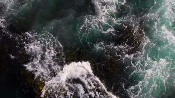 Draufsicht von oben. Meereswellen wälzen sich an der felsigen Küste. — Stockvideo
