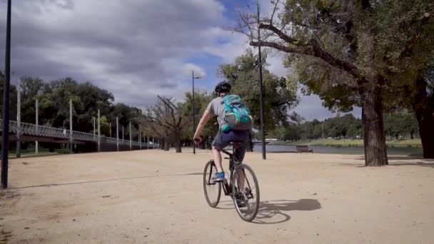 Een man op een fiets, die door de stad rijdt. Toerist in zonnebril met rugzak. — Stockvideo