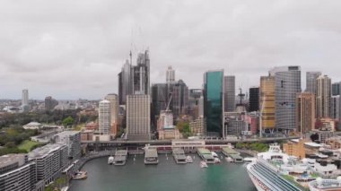 Sydney şehir merkezinden yukarıdan bak. Çerçevede gökdelenler, liman, yolcu gemisi ve körfez.