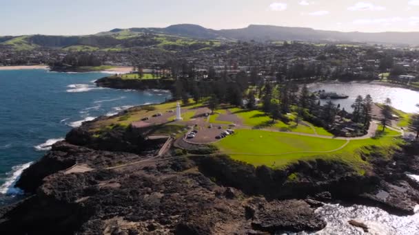 Kiama, a resort town in Australia. An aerial view of the picturesque rocky headland. A white lighthouse stands on the ocean. — Stock Video