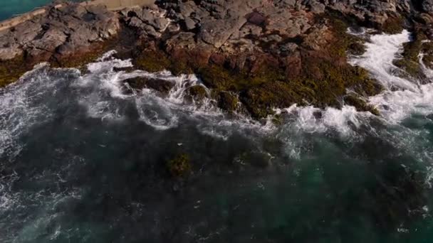 Bovenaanzicht van boven. Oceaan golven rollen op de rotsachtige kust. — Stockvideo