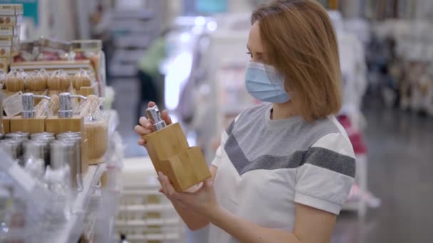 Una hermosa mujer con una máscara médica vino de compras. Una ferretería, la chica elige accesorios para el baño . — Vídeos de Stock