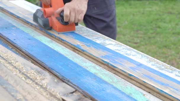 Electro shirt en oude planken. De handen van een arbeider met gereedschap op hout — Stockvideo