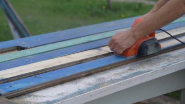 Elektro gömlek ve eski tahtalar. Ahşap bir aletle çalışan bir işçinin elleri