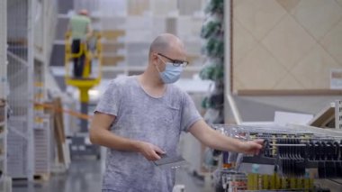 İnşaat atölyesindeki bir adam spatulayı seçer. İnşaata hazırlanılıyor.