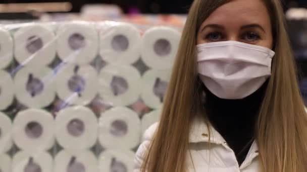 Mädchen mit Maske auf dem Markt auf Toilettenpapier-Hintergrund. — Stockvideo