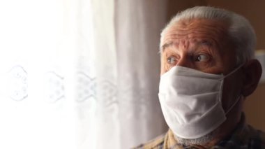 Koronavirüs salgınından umudunu yitirmiş kıdemli bir adam, tıbbi maske takarak emekli oldu.