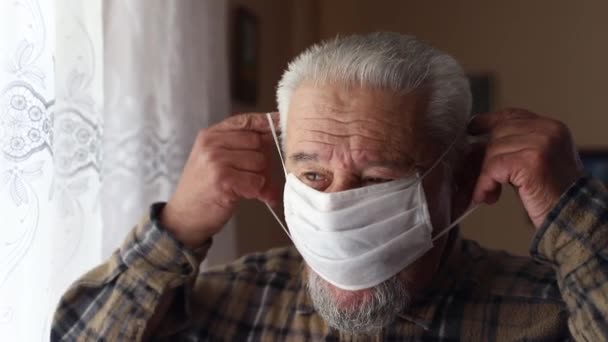 Senior man med tung andning i en mask hemma. Pamdemi av coronavirus — Stockvideo