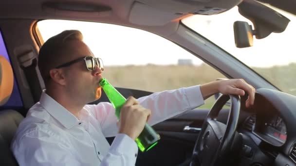 Ung man med ölflaska sitter i bilen och täcker ansiktet från polisbil ljus. Körförmåga under alkoholpåverkan — Stockvideo