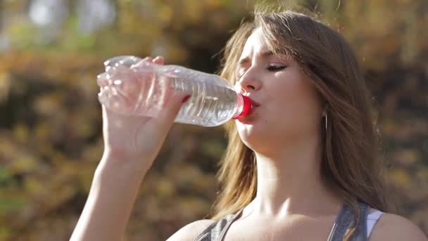 Slim mladá žena pitná voda po tréninku — Stock video