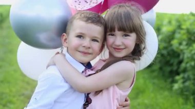 Parkta yürürken bir çocuk. Yaz günü kız ve erkek kardeşlerin portresi. Parktaki mutlu çocuklar.