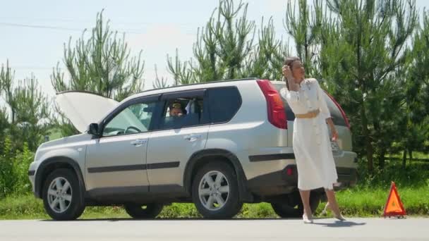 一个女人在路上求人帮忙 一个女人在路上车子抛锚的时候求人帮忙 — 图库视频影像